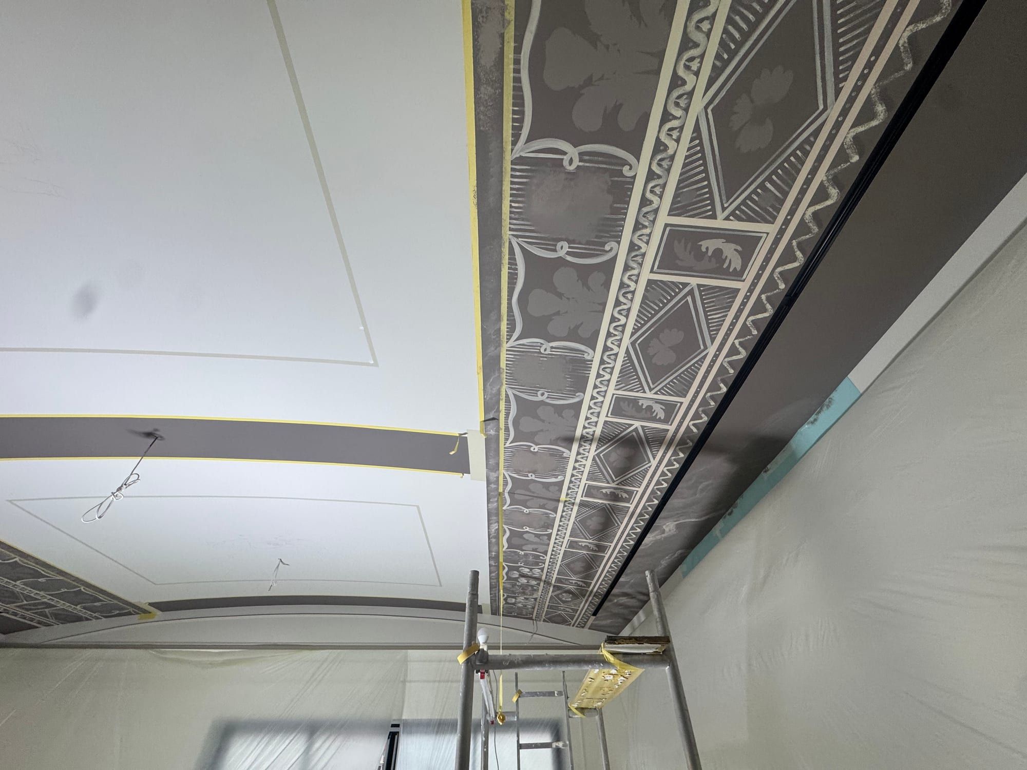 Monochrome ornamental band running along the edge of a ceiling above a wall