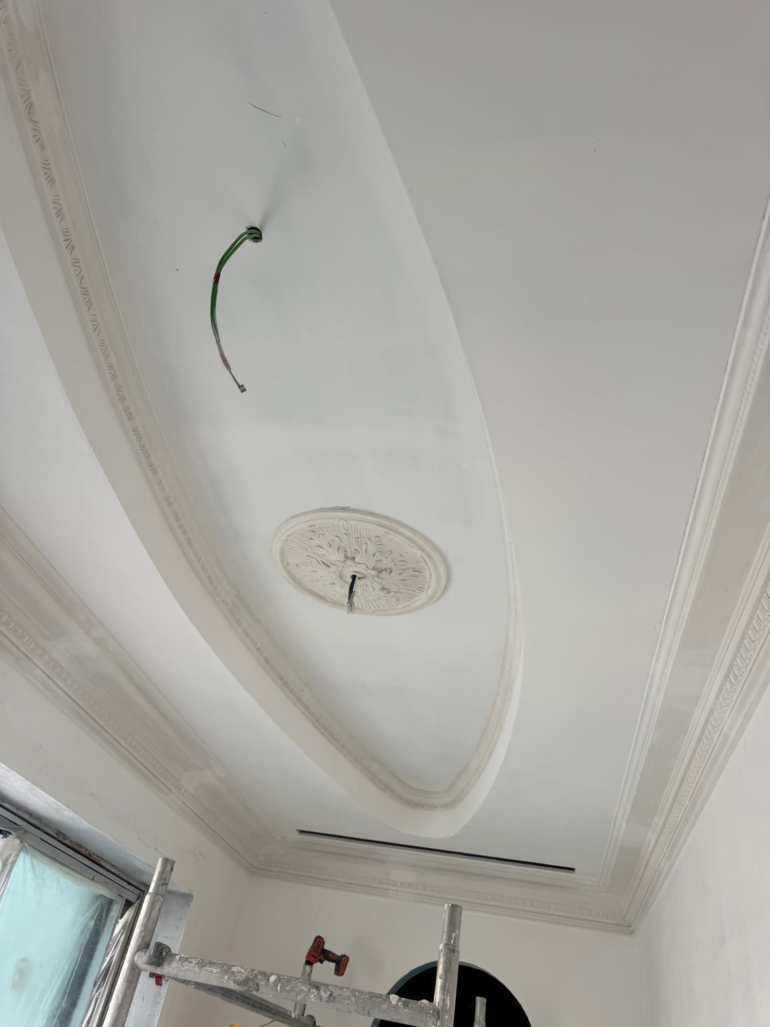 Oval ceiling recess edged with a run moulding, with a plaster medallion at its centre